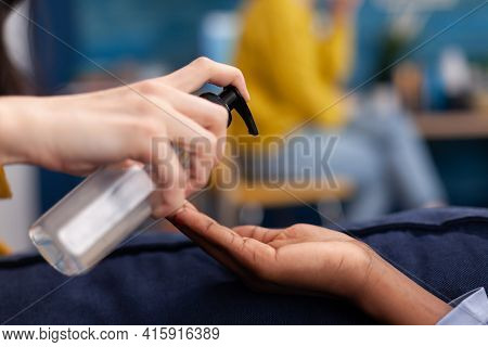 Close Up Of Multi Ethnic Friends Using Hand Gel