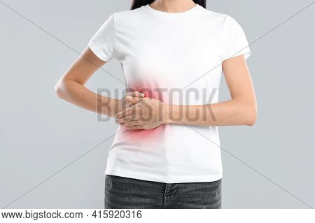 Woman Suffering From Liver Pain On Grey Background, Closeup