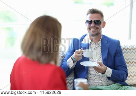 Businesswoman And Businessman Drink Coffee In Cafe