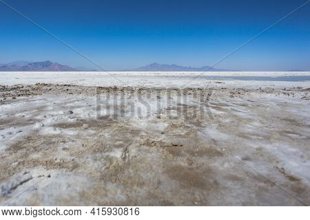 World famous Bonneville Salt Flats outside Salt Lake City Utah with mountains and blue skies. Detail of the salt on the ground