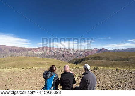 Humahuaca, Argentina, Dec 21: Three Undefined Tourists Sitting In Front Of The Mountain Of Fourteen 