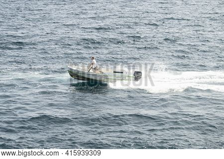 The White Fast Boat Sails By Sea. Sunny Autumn Day. Side View. Crimea, Sudak - 10 October 2020.