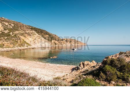 A Sailing Yacht Is Moored In A Bay On The Translucent Mediterranean Sea On The Coast Of La Revellata