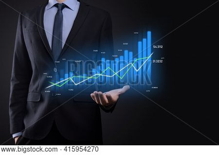 Business Man Holding Holographic Graphs And Stock Market Statistics Gain Profits. Concept Of Growth