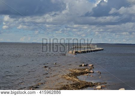 Landscape With A Lake, Which In The Spring Floods Flooded A Wooden Footpath Immersed In River Water.
