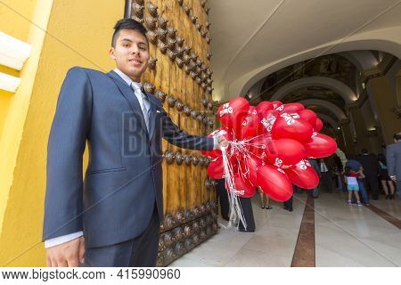 Trujillo, Peru - Jan 1: Smiling Peruvian Young Man Dressed With A Suit And Holding Balloons At The E