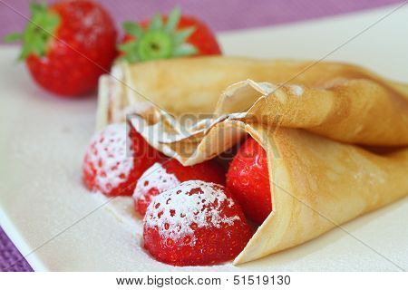 Crepe with strawberries dusted with icing sugar