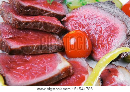 underdone beef meat with vegetables on white plate