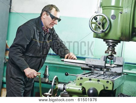 milling machine operator working in factory workshop