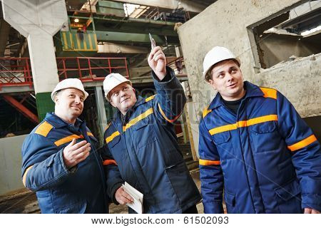 three industrial engineer chief discussing enterprise development in house-building plant