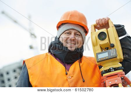 surveyor worker portrait with theodolite transit equipment at road construction site outdoors