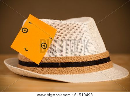 Drawn smiley face on a post-it note sticked on a hat