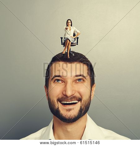 earnest woman pointing at something and sitting on the head of smiley man