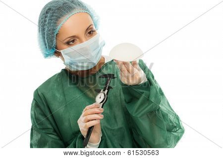 Plastic surgeon woman with silicon breast implants and calliper 