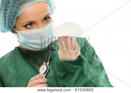 Plastic surgeon woman with silicon breast implants and calliper 