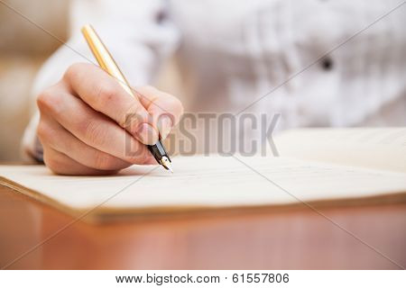 Hand with pen and music sheet