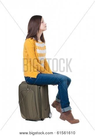 side view of walking  woman  in cardigan sits on a suitcase. beautiful  girl in motion.  backside view of person.  Rear view people collection. Isolated over white background.