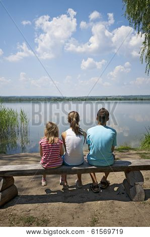 Kids Sitting On The Lakeside
