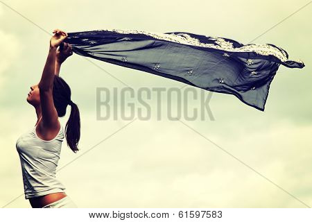 Girl with voile against cloudy sky