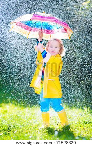 Funny Toddler With Umbrella Playing In The Rain