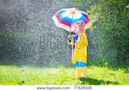 Funny Toddler With Umbrella Playing In The Rain