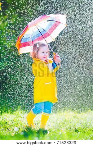 Funny Toddler With Umbrella Playing In The Rain