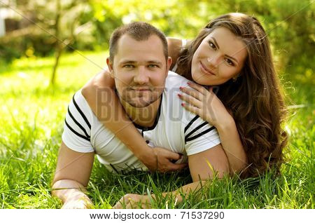 Young couple laying on park lawn