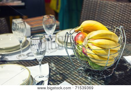 Table with glasses and vase for fruits