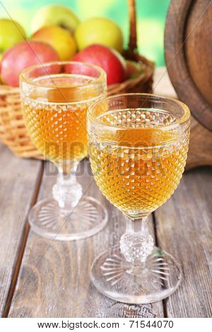 Still life with tasty apple cider and fresh apples, on nature background