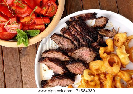 Flank Steak With Fries Onion Rings And Salad