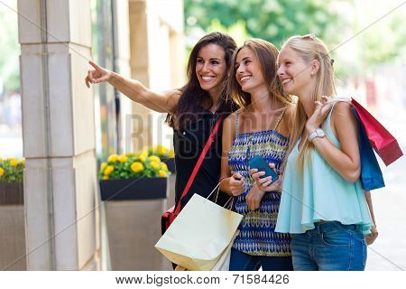 Group Of Beautiful Girls Looking At The Shop Window.