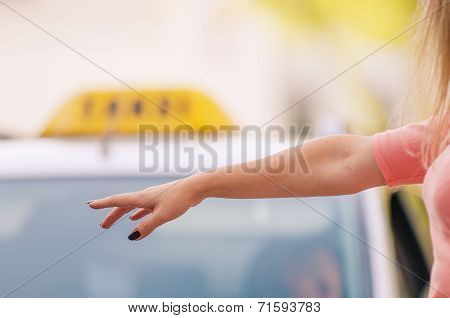 woman raising her arm to call a taxi