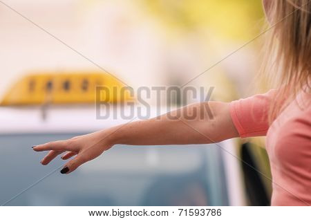 woman raising her arm to call a taxi