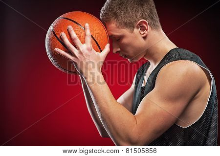 Caucasian male basketball player pressing ball to his forehead