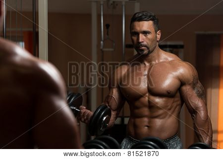 Bodybuilder Doing Heavy Weight Exercise For Biceps