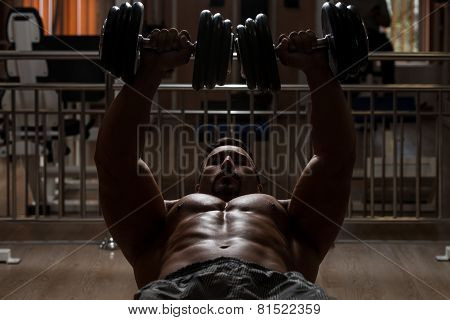 Bodybuilder Doing Exercise For Chest With Dumbbells