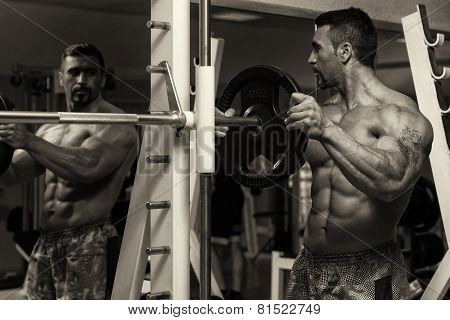 Bodybuilder Putting Weights On Bar In Gym