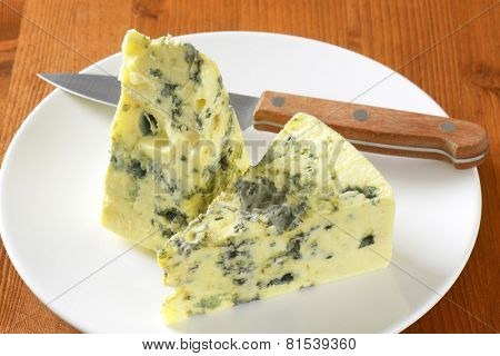 two triangles of ripe gorgonzola, on the plate with sharp knife