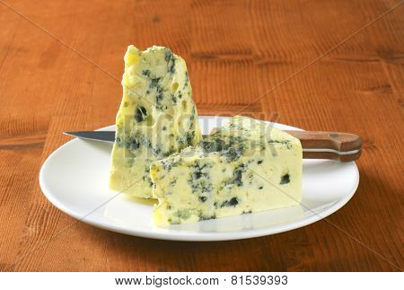 two triangles of gorgonzola served on the plate with sharp knife