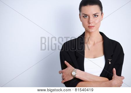 A young woman standing, isolated on graybackground