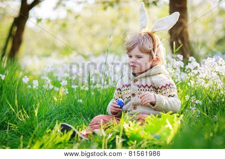 Cute Happy Little Boy Wearing Easter Bunny Ears At Spring Green Grass