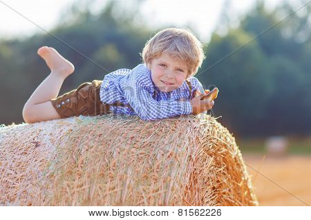 Funny Little Kid Boy Lying On Hay Stack  And Smiling