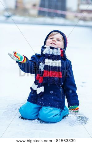 Cute Little Funny Boy In Colorful Winter Clothes Having Fun With
