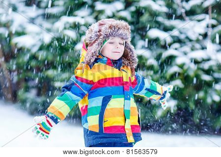Cute Little Funny Boy In Colorful Winter Clothes Having Fun With