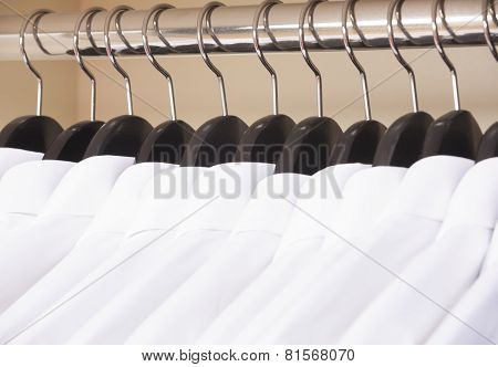 variety of colorful shirts on black hangers