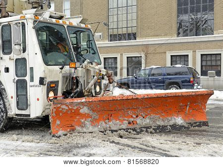 Truck with snowplow clearing street after snowstorm