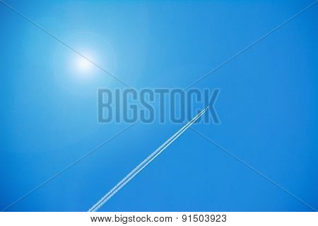Airplane Contrails Under A Shining Sun