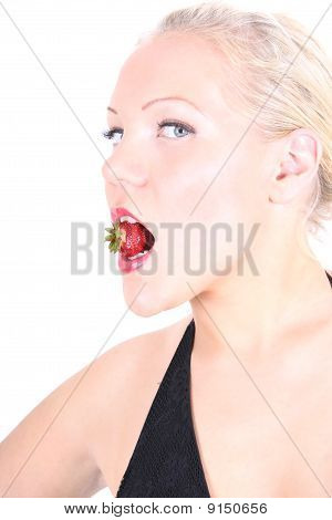 Foto luminosa della giovane bionda con fragola In bocca