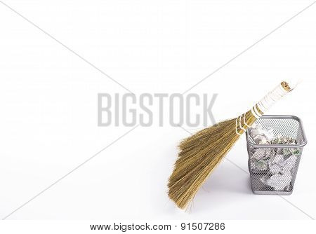 isolated besom and wastebasket with white waste paper