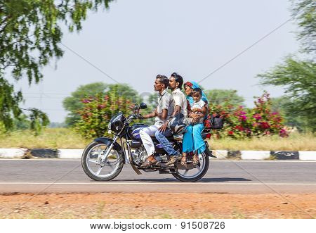 Mother, Father And Small Child Riding On Scooter Through Busy Highway